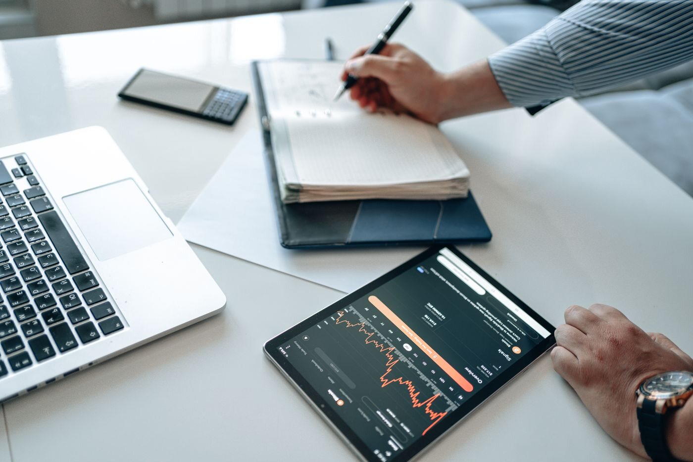 Business professional reviewing visitor and sales data on a tablet and laptop